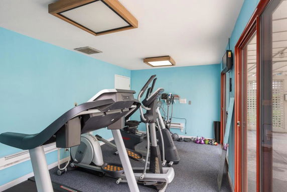 Indoor gym area with exercise equipment like treadmills and elliptical machines.