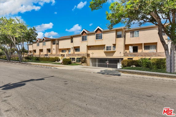 Front view of a multi-story residential building with garages.