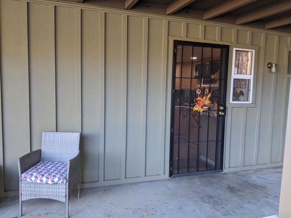 Entrance area of a building with a chair and a decorated door.