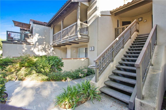 Front view of a house with an exterior staircase and balcony.