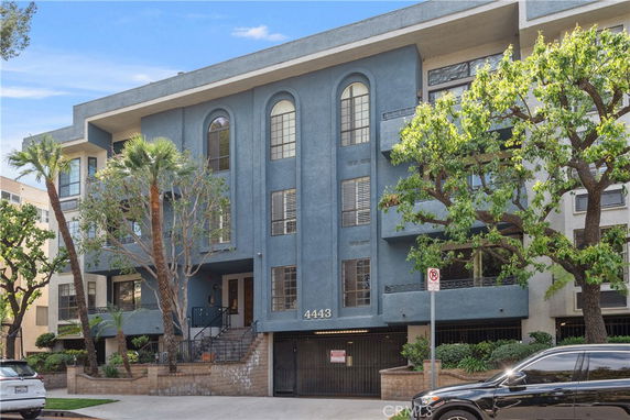 Front view of a multi-story apartment building with a blue facade
