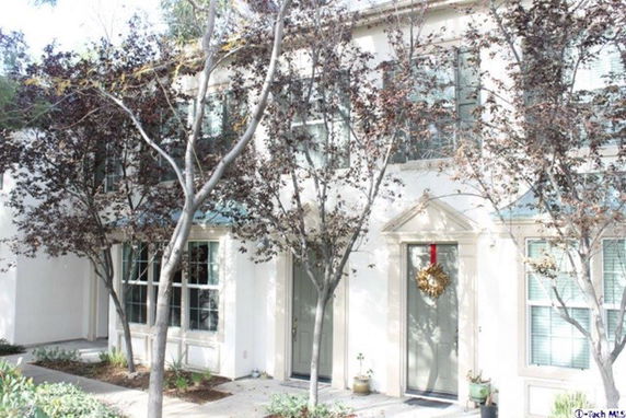 Front view of a two-story house with large windows and a wreath on the door.