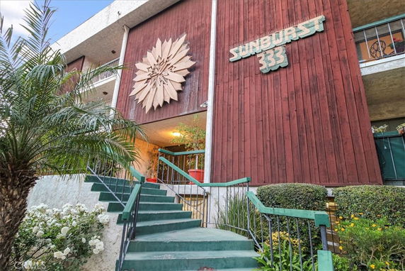 Front view of a building with a distinctive wooden facade and a decorative starburst design.