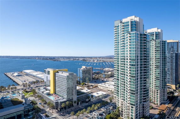 Panoramic view of tall buildings overlooking a body of water with boats.