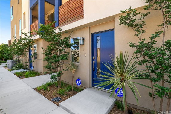 Front view of a townhouse with blue doors and modern design elements.