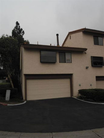 Front view of a two-story house with a tile roof and a garage.