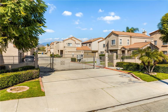 Front view of a gated residential complex with multiple two-story houses.
