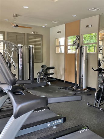 Indoor gym area with exercise equipment and machines.