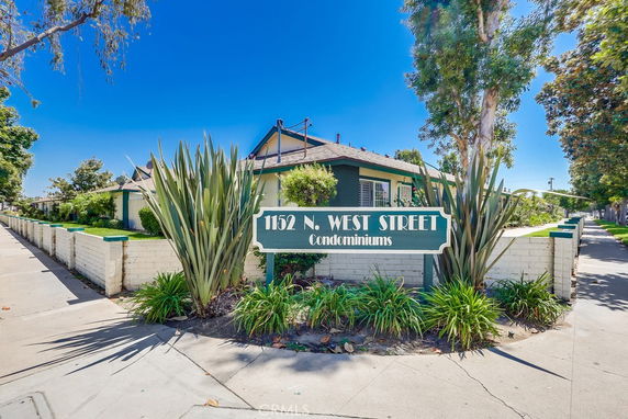 Front view of a single-story condominium complex with a green and white color scheme.
