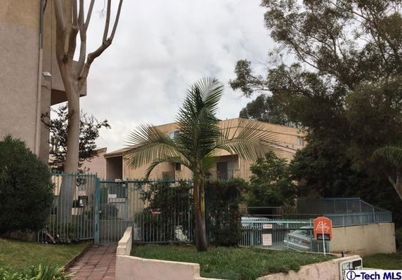 Front view of a residential building with gated entrance.