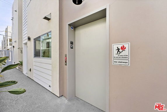 Front view of a modern building with an exterior elevator entrance.