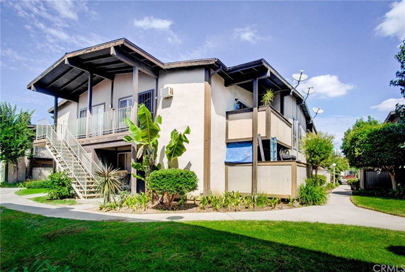 Front view of a two-story building with exterior staircases and balconies.