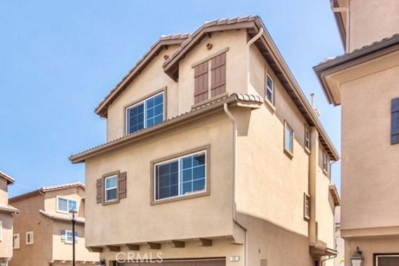 Front view of a multi-story house with multiple windows and a sloped roof.