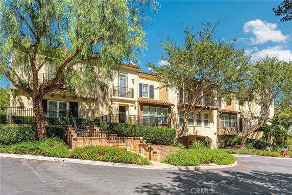 Front view of a two-story house with multiple balconies and a stairway entrance.