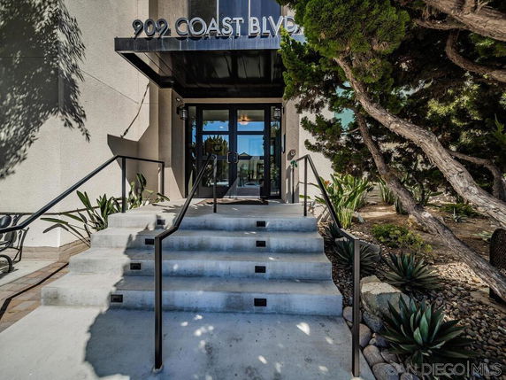 Entrance view of a building with stairs and a glass door.