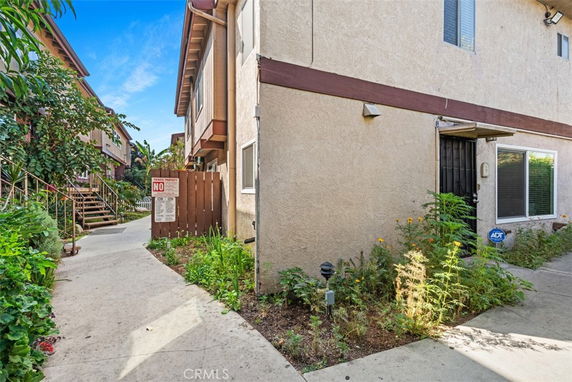 Front view of a two-story house with side pathways and entrance.