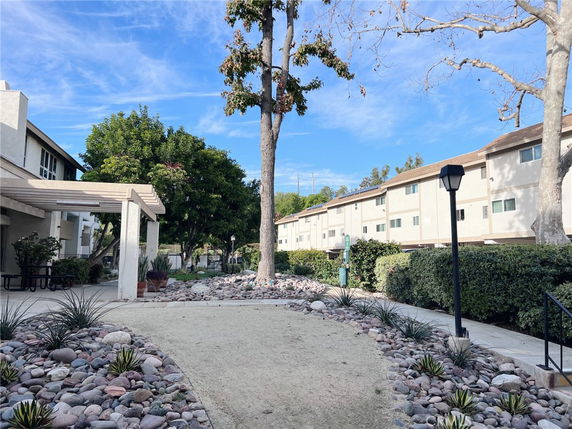 Outdoor view of a residential complex with walking paths and landscaped areas.