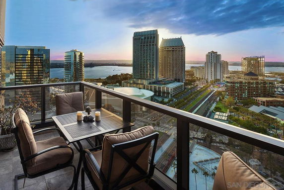 View from a balcony overlooking a cityscape with tall buildings and a waterfront.