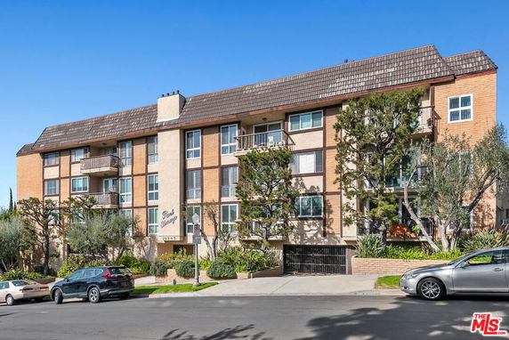 Front view of a multi-story apartment building with balconies.