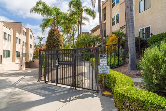 Front view of a multi-story residential building with gated entrance.