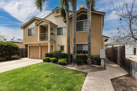 Front view of a two-story house with a balcony and double garage.