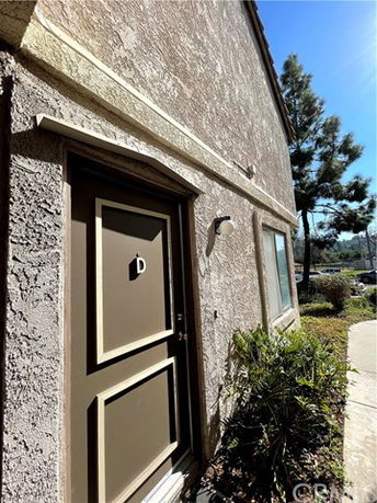 Front view of a building entrance with a labeled door and an exterior light fixture.