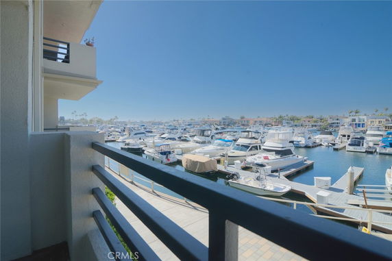 View from a building's balcony overlooking a marina filled with boats and distant buildings.
