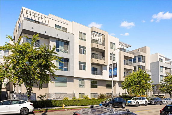 Front view of a modern multi-story apartment building with balconies.