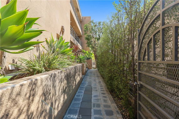 Side view of a multi-story building with a walkway and garden.