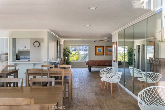 Interior view of a recreation room with a pool table, chairs, and tables.