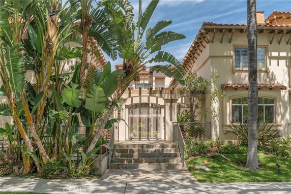 Front view of a two-story house with tiled roof and arched windows.