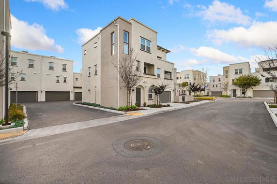 View of multiple modern buildings in a residential complex with garages.