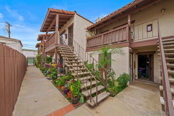 Front view of a multi-story residential building with external staircases and balconies.