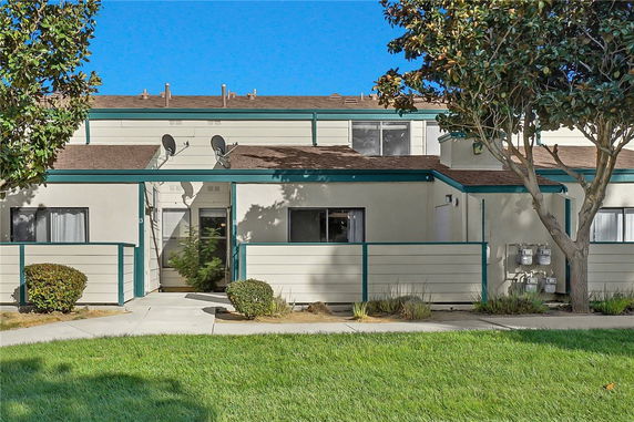 Front view of a two-story residential building with satellite dishes.