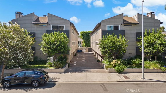 Front view of two-story residential buildings with unique angular roofs and entryway between.