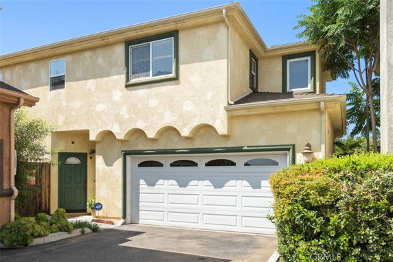 Front view of a two-story house with a white garage and green entrance door.