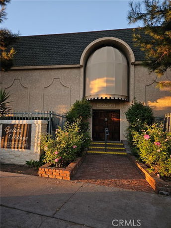 Front view of a condominium building with a unique arch design above the entrance.