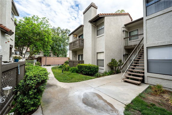 Front view of a two-story apartment building with balconies and outdoor stairs.