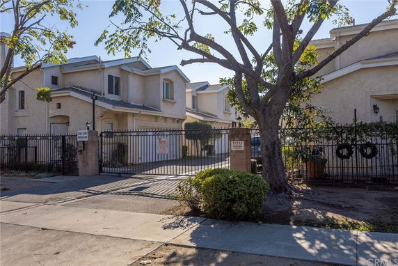 Front view of a two-story house with gated entrance.