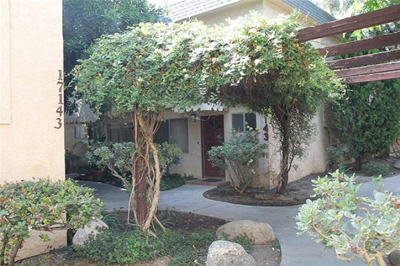 Front view of a house with a foliage-covered entryway.
