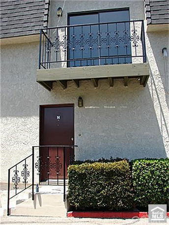 Front view of a two-story building with a small balcony above the entrance.
