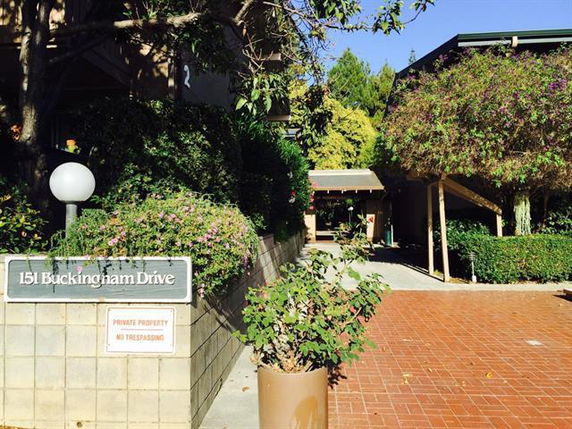 Front view of a building entrance with a sign that reads '151 Buckingham Drive.'