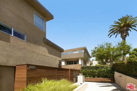 Front view of modern multi-story house with flat roofs and large windows.