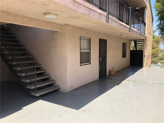 Front view of a building with external stairs and a balcony.