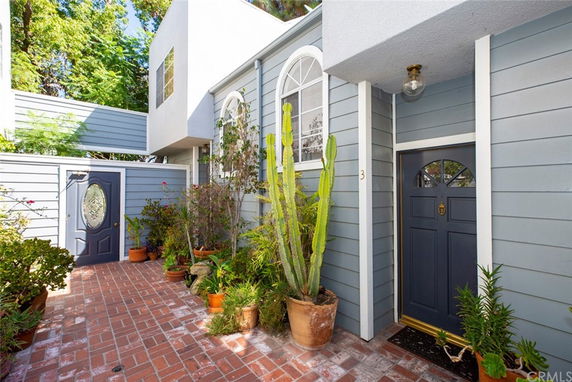 Front view of a house with a blue door and brick pathway.