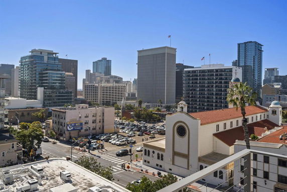 View of a cityscape with multiple buildings and a church with a red roof.