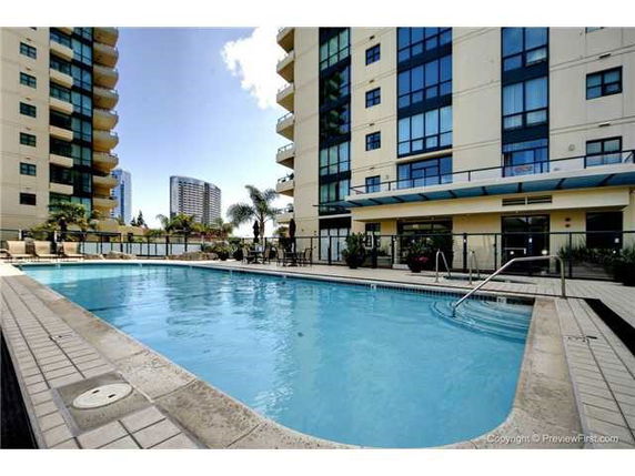 Outdoor swimming pool beside a multi-story building.