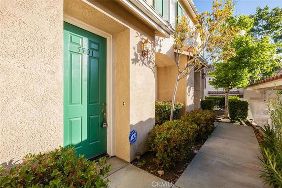 Front view of a house with a green door and beige exterior walls.