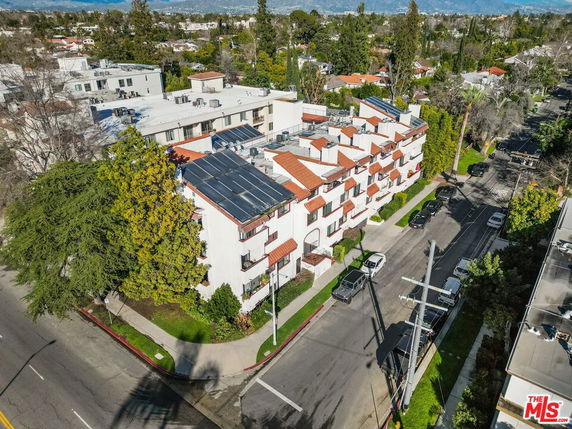 Aerial view of a multi-story building with solar panels on the rooftop.