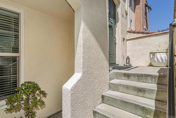 Entrance area of a multi-story house with steps leading to the front door.